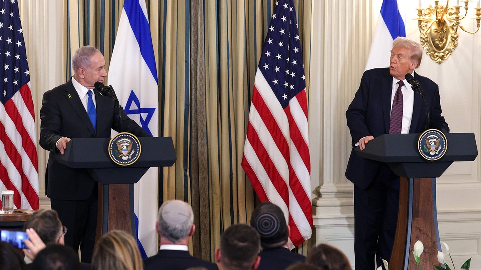 Color photograph of Benjamin Netanyahu and Donald Trump at two podiums side-by-side with American and Israeli flags in the background.