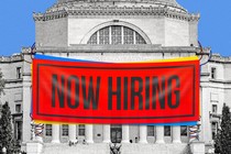 Columbia's library with a cartoonishly large and bright NOW HIRING sign hanging over it