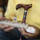 An older person holds a pillbox with sections for days of the week.