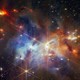 The interior of a nebula filled with many stars and clumpy clouds of gas illuminated in shades of blue, orange, and red