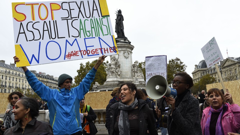 Protesters carry signs, one reading "Stop sexual assaults against women #WeToogether"