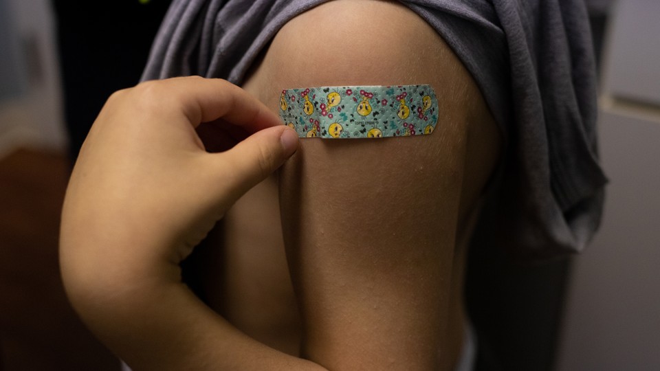 A kid's shoulder, with a Band-Aid, after a shot