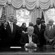 President Trump, Vice President Mike Pence, and faith leaders say a prayer in the Oval Office in September 2017. Several people have their hands on Trump's shoulders. Most of the people have their eyes closed.