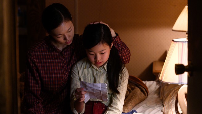 The Yi family examines a piece of paper