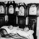 A couple sleeping, surrounded by clocks