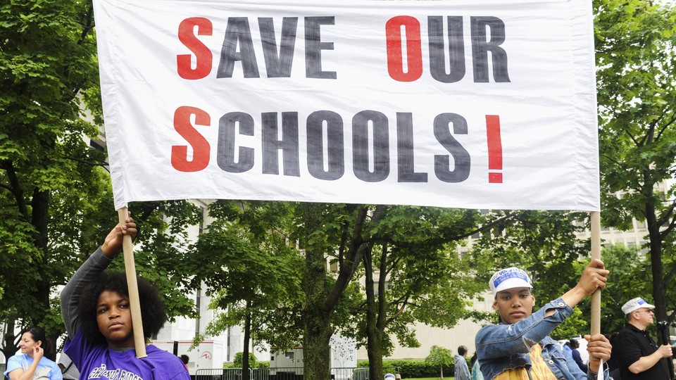 Students of the East Ramapo School District hold a sign that reads "Save our schools!" 