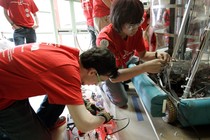 Two students work on a robot.