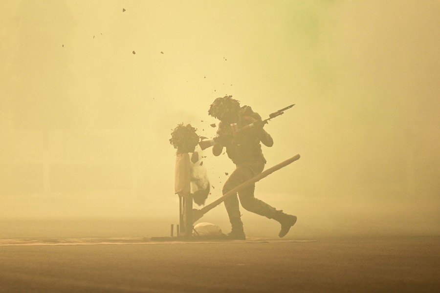 A soldier strikes a dummy with their rifle butt during an exercise.