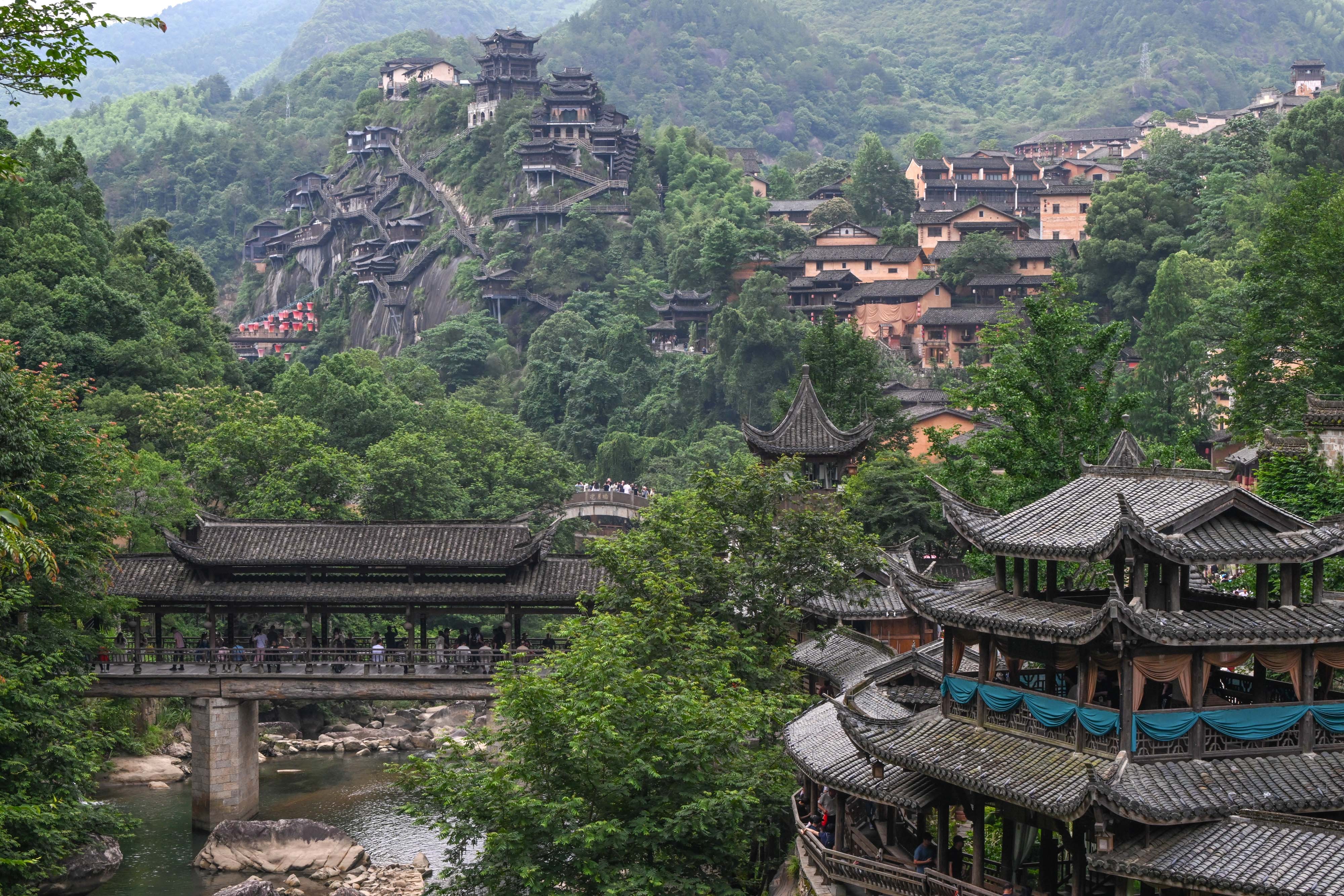 A view of traditional architecture and complex wooden structures along steep hillsides in China