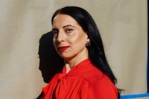 A photo of a woman with dark hair, bright-red lipstick, and a red blouse