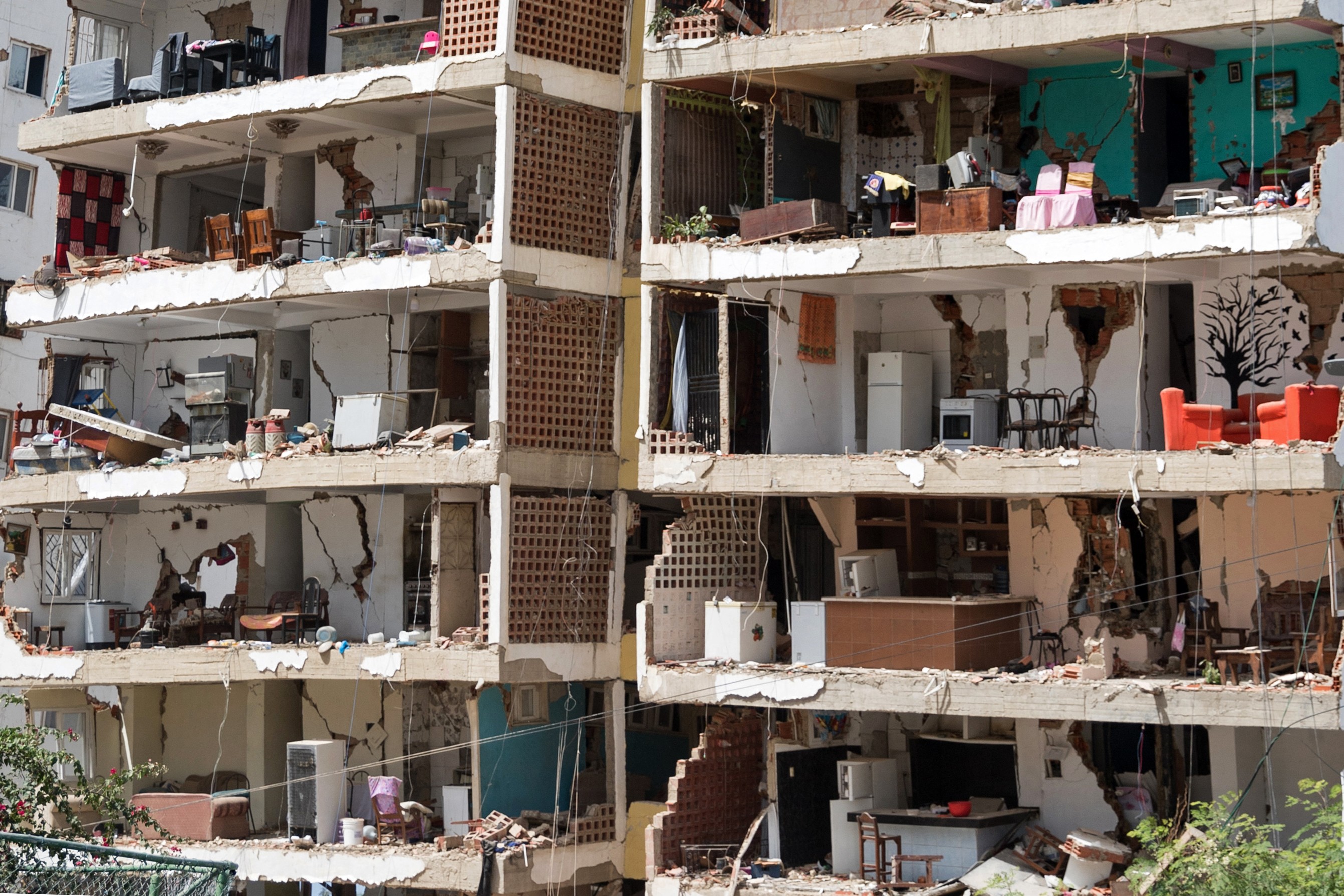 The interiors of about eight apartments, viewed from outside, after an outer wall of an apartment building collapsed