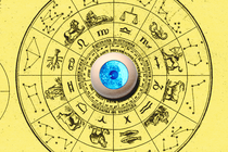 A blue artificial eyeball sits in the middle of a circular astrological chart.