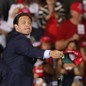 Ron DeSantis tosses hats to the crowd before the arrival of Donald Trump for his campaign event at Miami-Opa Locka Executive Airport in November 2020.