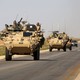 U.S. troops sit atop an armored vehicle on a road near the northern Syrian village of Ain Issa on June 3, 2017.