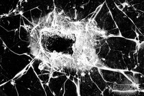 A photo of window glass splintered by a bullet impact.