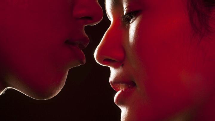 A close up of two people about to kiss
