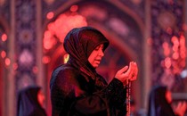 A woman prays outside a mosque.