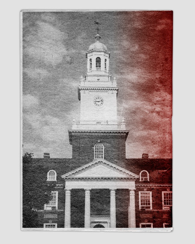 Black and white image of a college building with red color seeping in from the right