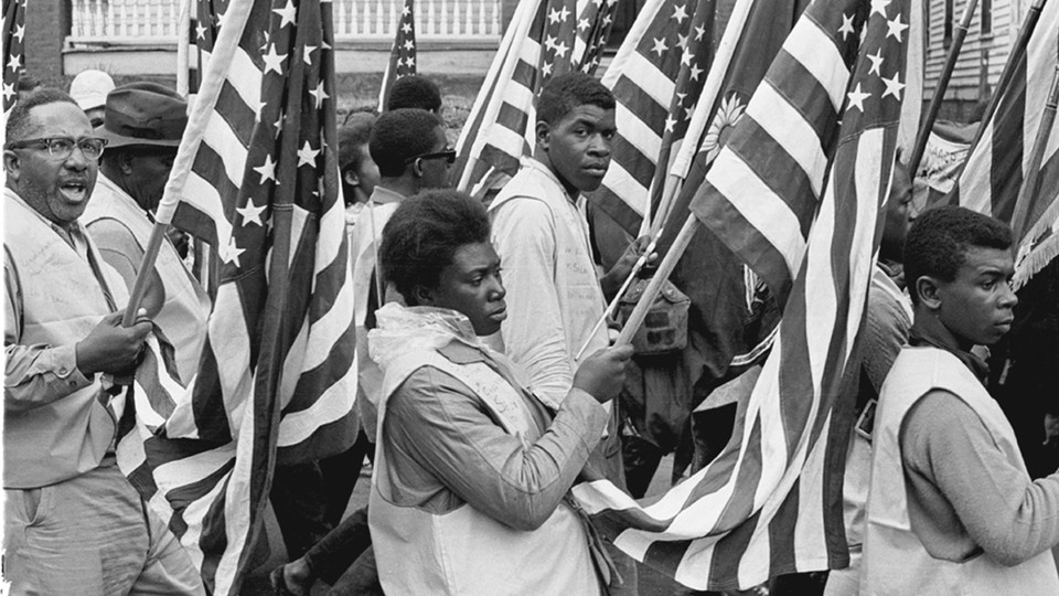 A photo of Black protesters carrying American flags