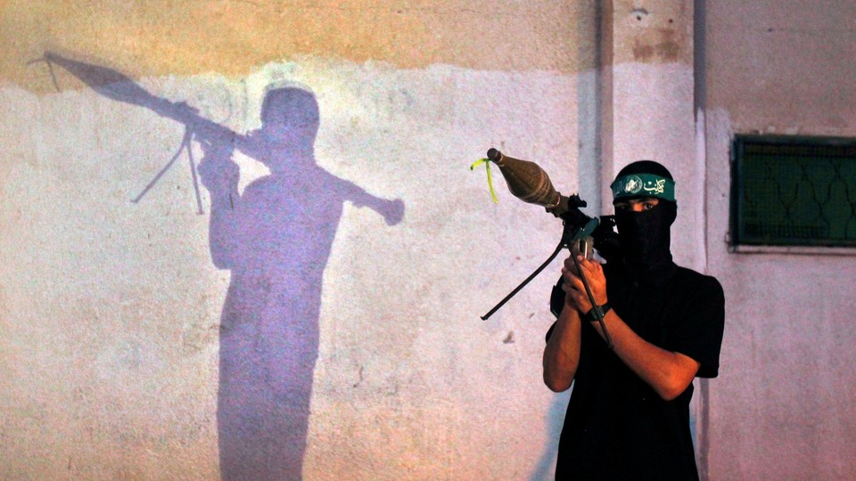 A masked member of Hamas holds a weapon in 2013.