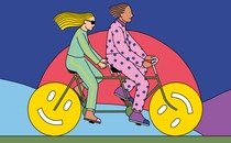 Two people ride a tandem bicycle, the wheels of which are smiley faces.