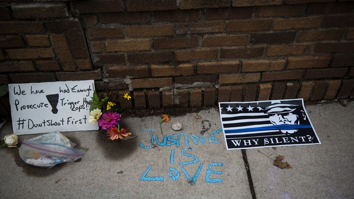 Memorial flowers and posters protesting the shooting of Justine Damond by police