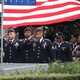 U.S. soldiers salute the casket of U.S. Army Sergeant La David Johnson with U.S. flags flying in the background.