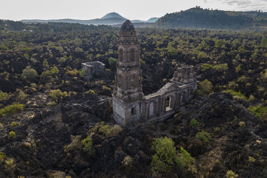 The ruins of an old church sit in a rough lava field.