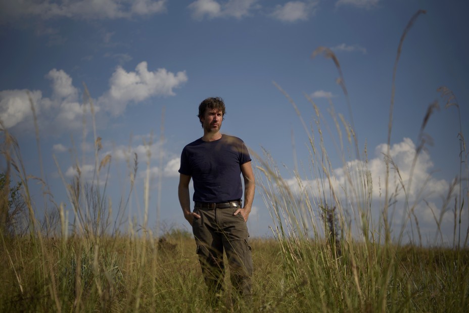 Veldman standing in a field of grass with blue sky above