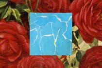 A piece of torn-up blue paper against a backdrop of red roses