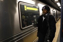 A conductor stands next to a stalled train in New York City after a power failure stopped multiple subway lines in April 2017.