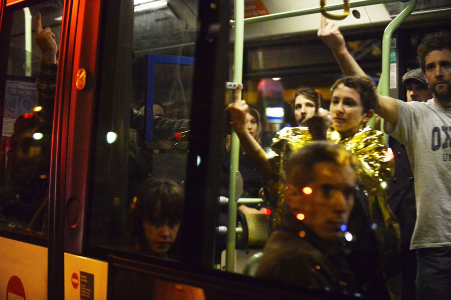 People on a bus hold up their middle fingers at someone or something on the other side of the window.