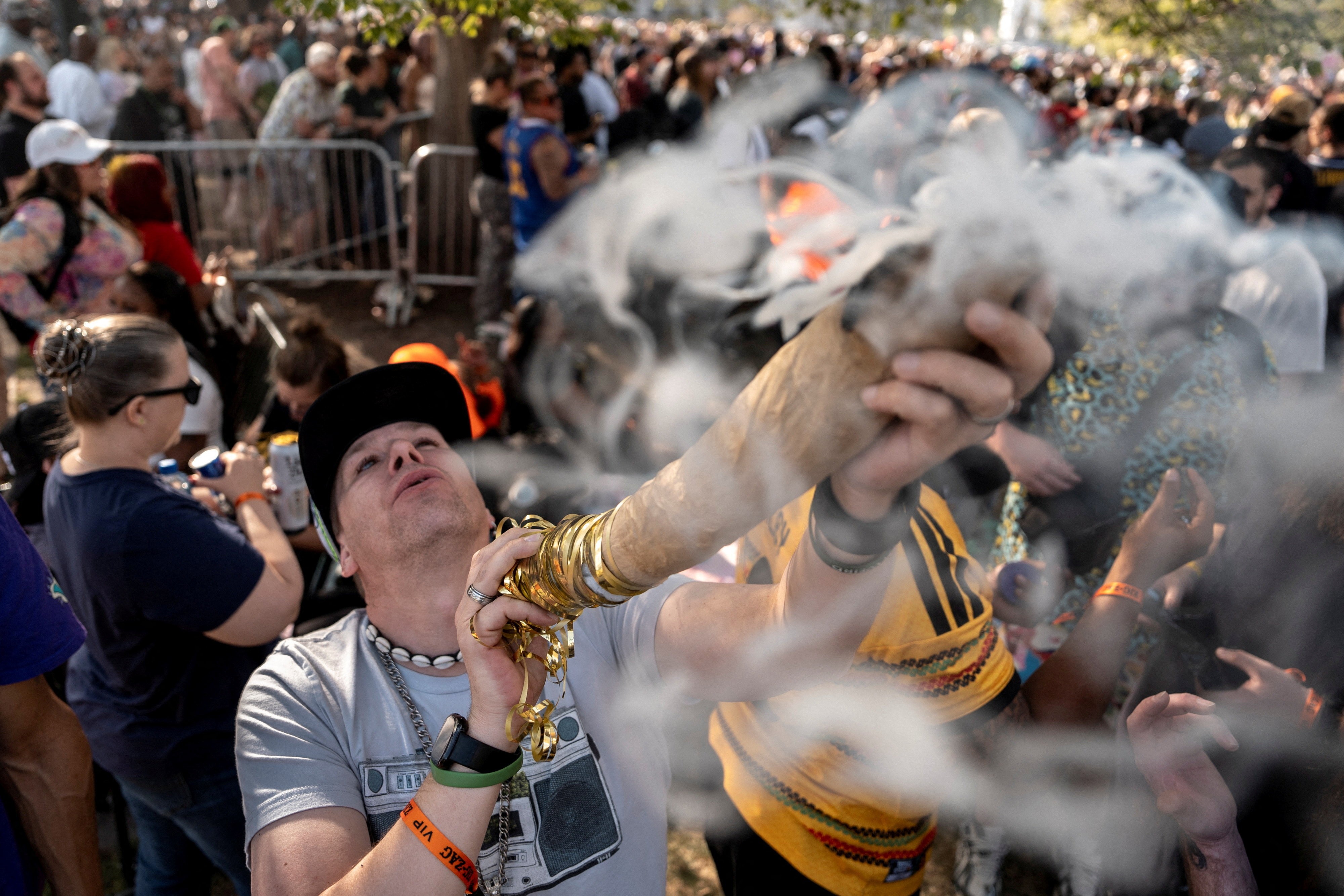A person smokes what appears to be an enormous blunt in a crowd celebrating a 420 festival.