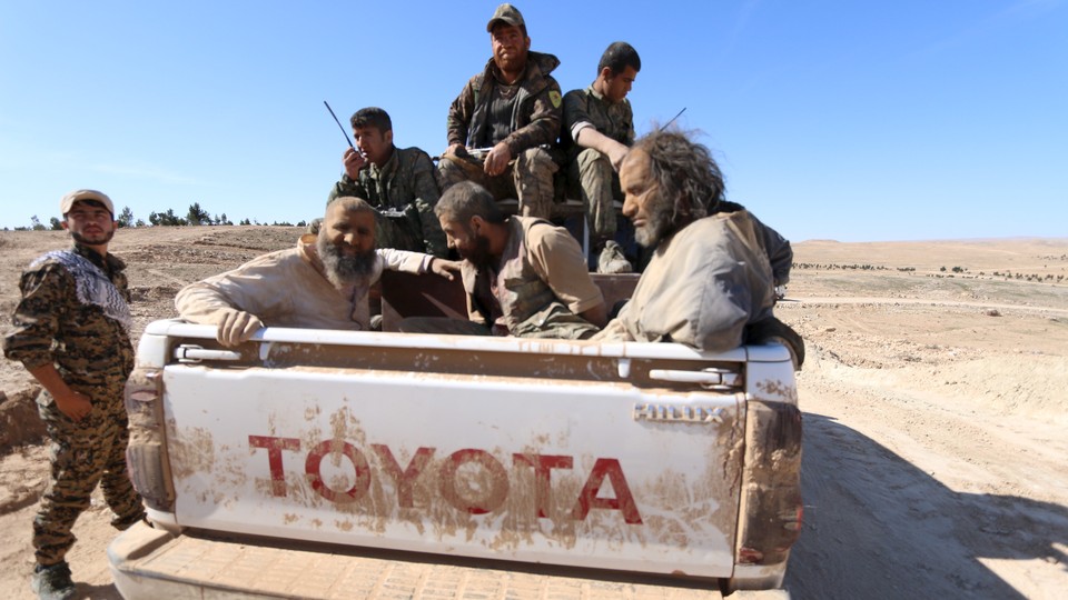 Syrian Democratic Forces soldiers transport captured Islamic State fighters in a pickup truck in Syria in 2016.