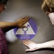Two students place a new sticker on the door at the ceremonial opening of a gender neutral bathroom at Nathan Hale High School on May 17 in Seattle.