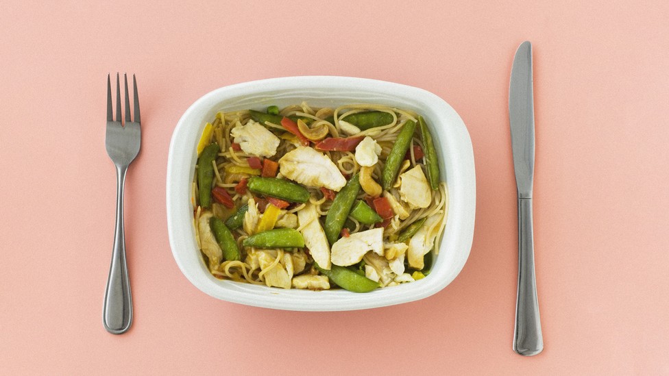 A microwave-dinner plate of pasta with chicken and vegetables