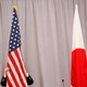 A worker adjusts the U.S. flag before Japanese Prime Minister Shinzo Abe addresses media following a meeting with President-elect Donald Trump in New York City on November 17, 2016.