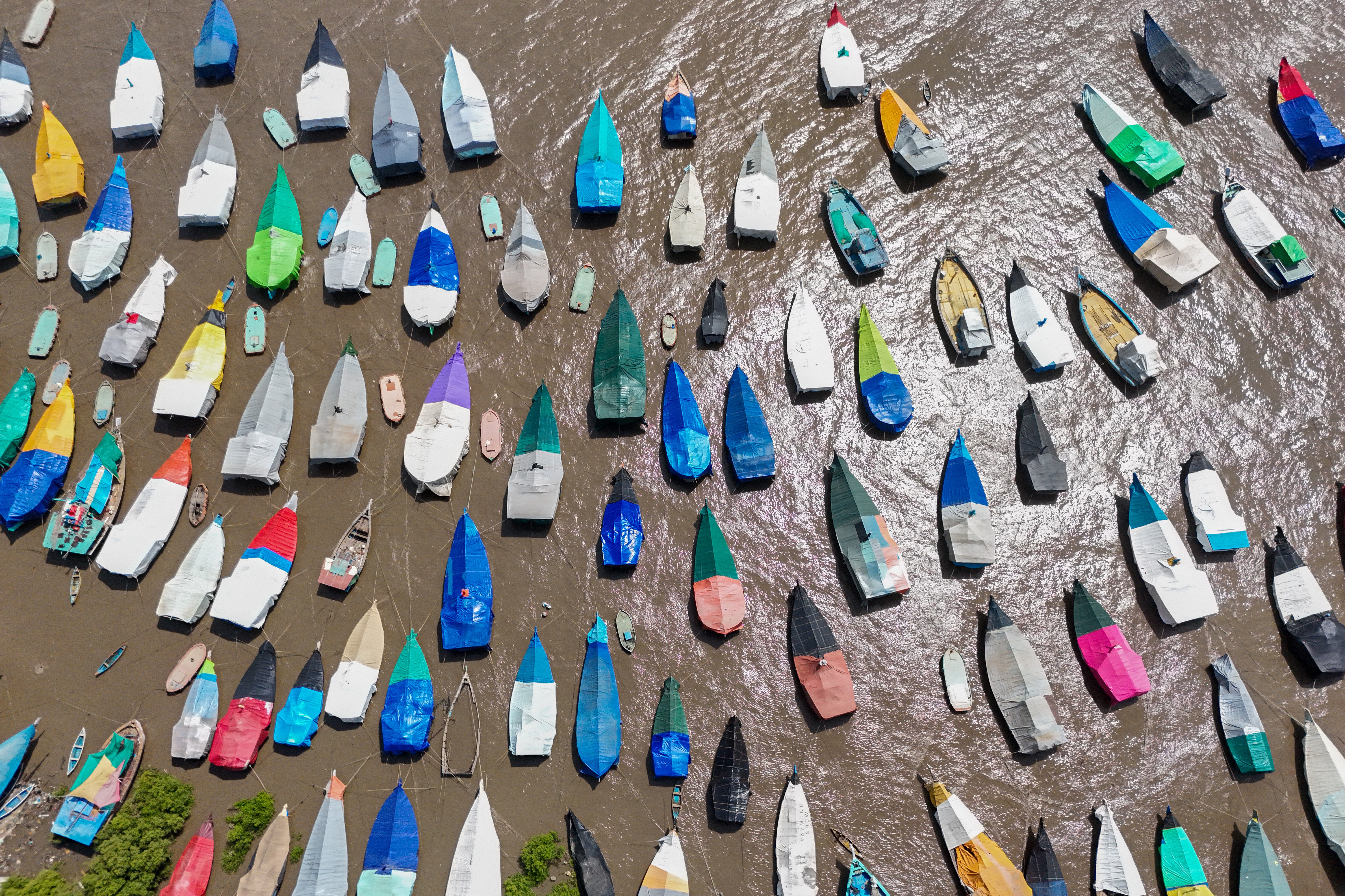 An aerial view of dozens of covered fishing boats.
