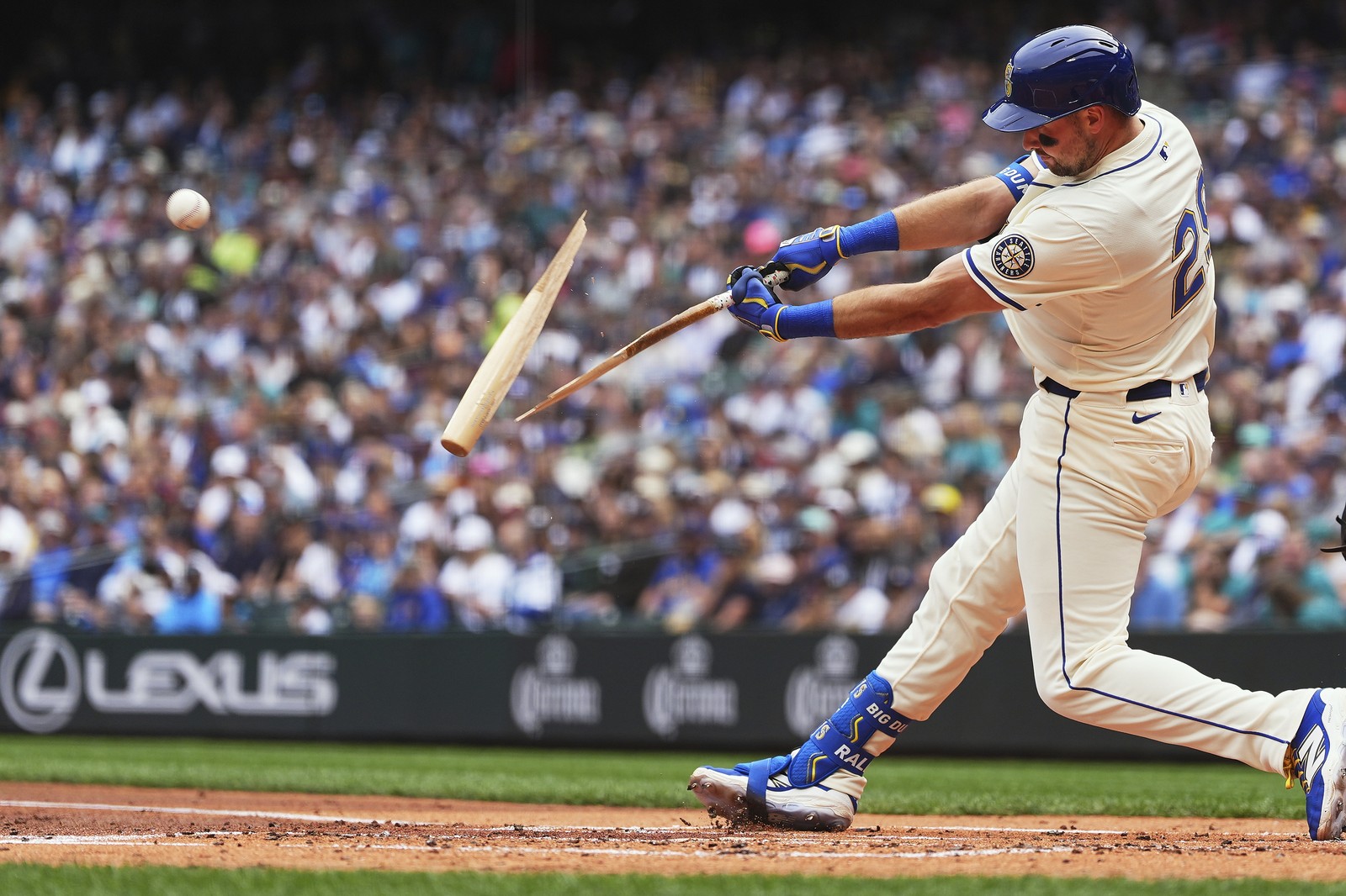 A baseball player swings and breaks his bat during a game.