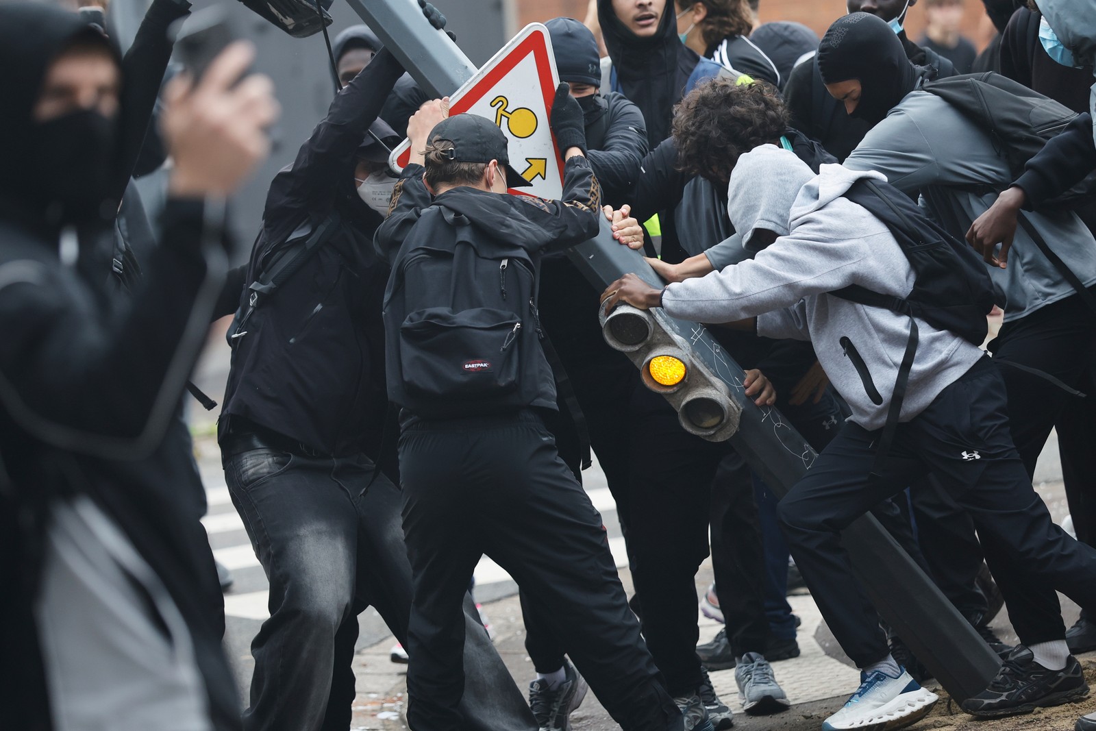 Students protesters tear down a traffic light.