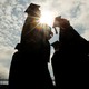 The silhouettes of several college graduates 