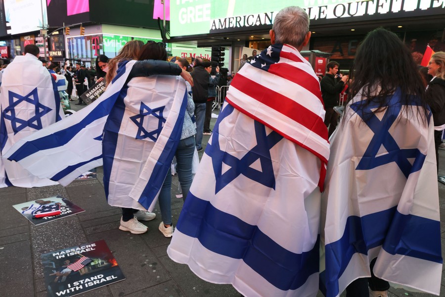 People gather in Times Square, many of them wearing Israeli flags draped over their shoulders.