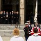 Photo of the Cheney family outside the National Cathedral watching as men in uniform carry Dick Cheney's casket.