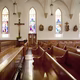 Pews and stained-glass windows in a church.