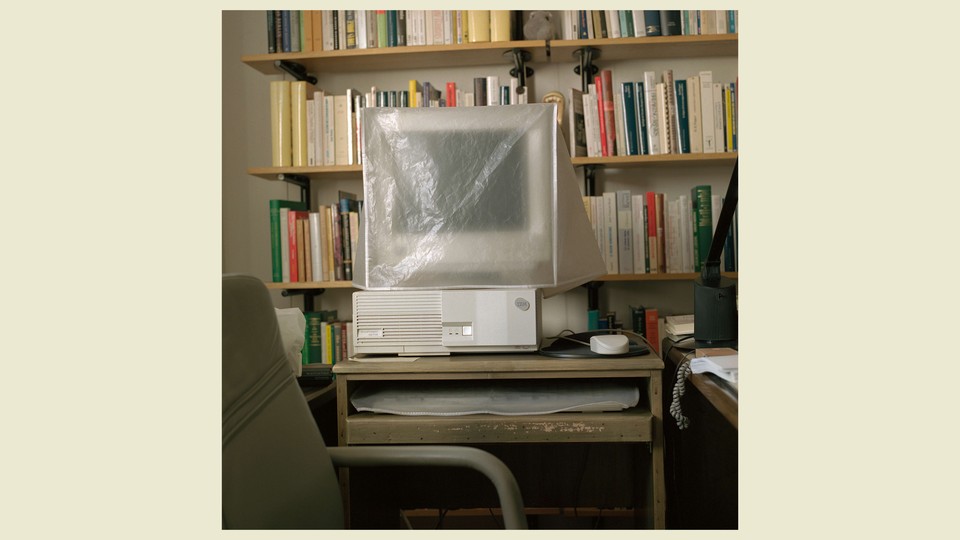 A computer at a desk wrapped in plastic