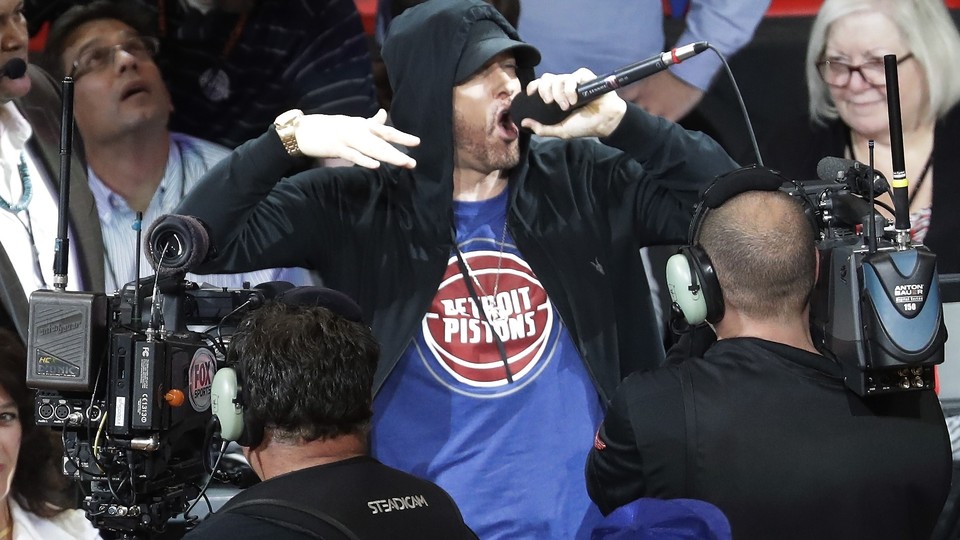 Eminem yells to the crowd before the start of an NBA basketball game between the Detroit Pistons and the Charlotte Hornets, Wednesday, Oct. 18,2017, in Detroit.