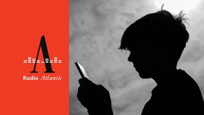 A black-and-white photograph shows a teenage boy looking at a smartphone.