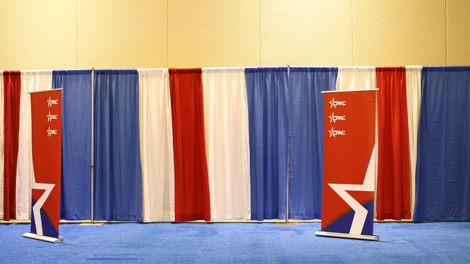 A CPAC banner and red, white, and blue curtains