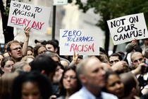 People hold signs reading "say no to racism every day," "zero tolerance for racism," and "not on our campus!"