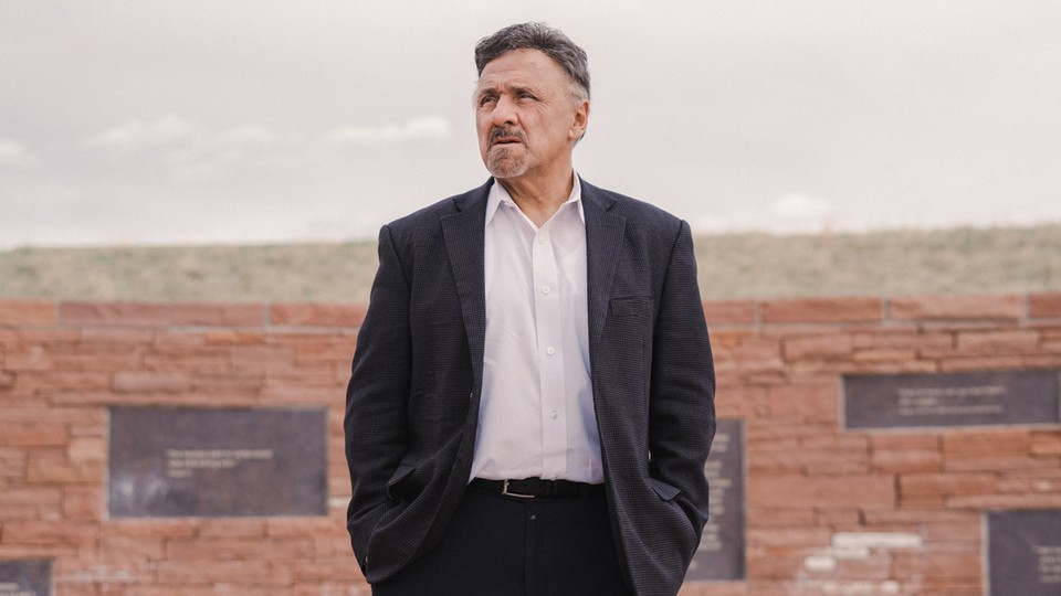 A photograph of Frank DeAngelis in front of the Columbine Memorial